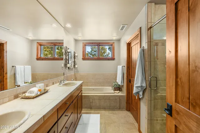 a bathroom with a tub a sink and glass door