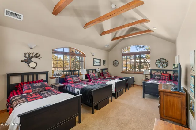 a bedroom with two beds and a flat screen tv