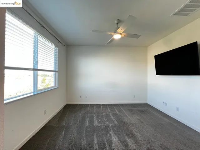 an empty room with a flat screen tv and a window