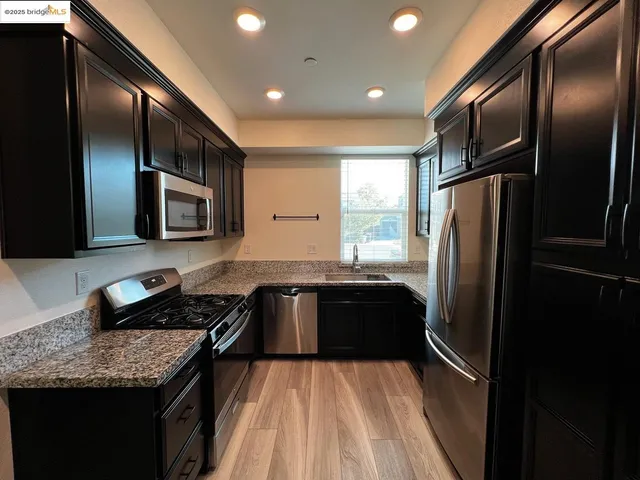 a kitchen with granite countertop stainless steel appliances and wooden cabinets