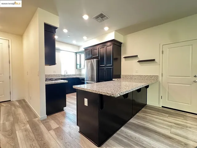 a kitchen with stainless steel appliances granite countertop a refrigerator and a sink