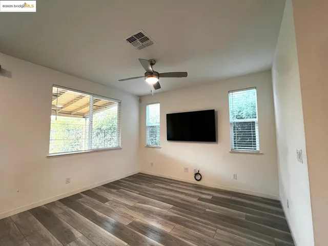 a view of a livingroom with wooden floor and a flat screen tv