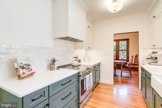 a kitchen with a sink and wooden floor