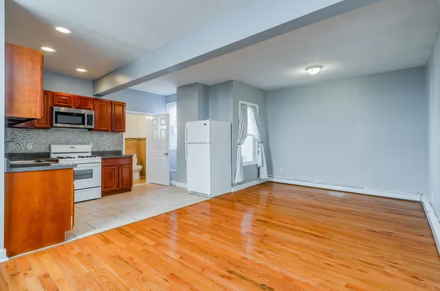 a large kitchen with stainless steel appliances granite countertop a stove a sink and a refrigerator