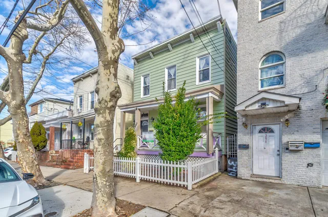 a view of a brick house with a small yard and plants