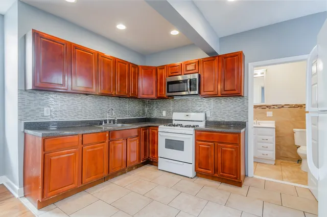 a kitchen with stainless steel appliances granite countertop a stove sink and cabinets