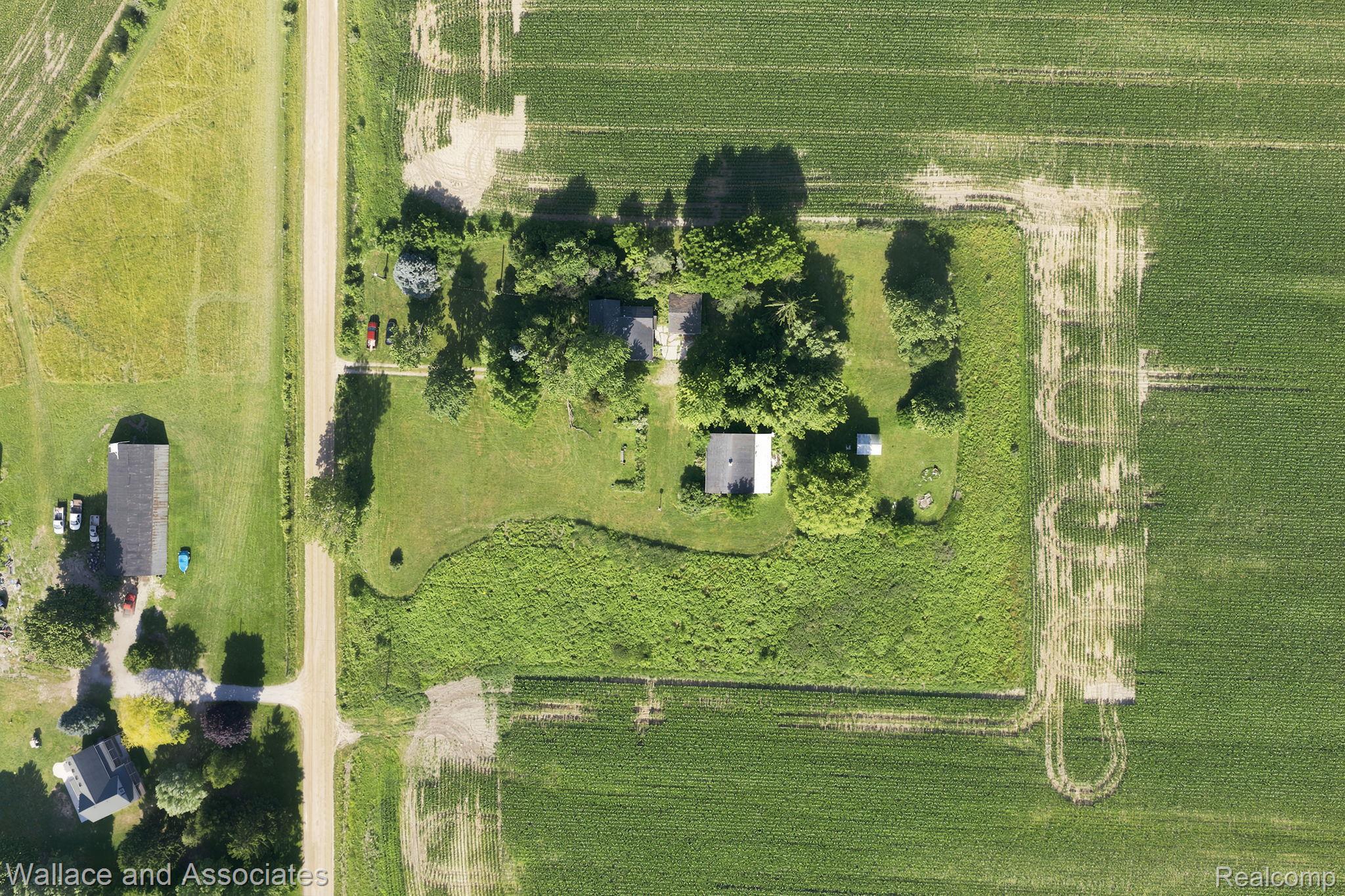 5949 Roach Road Croswell, MI 48422 - Photo 4 of 48 Aerial view of a rural property featuring multiple structures, mature trees, and expansive green spaces