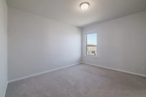 an empty room with a window and a bathroom