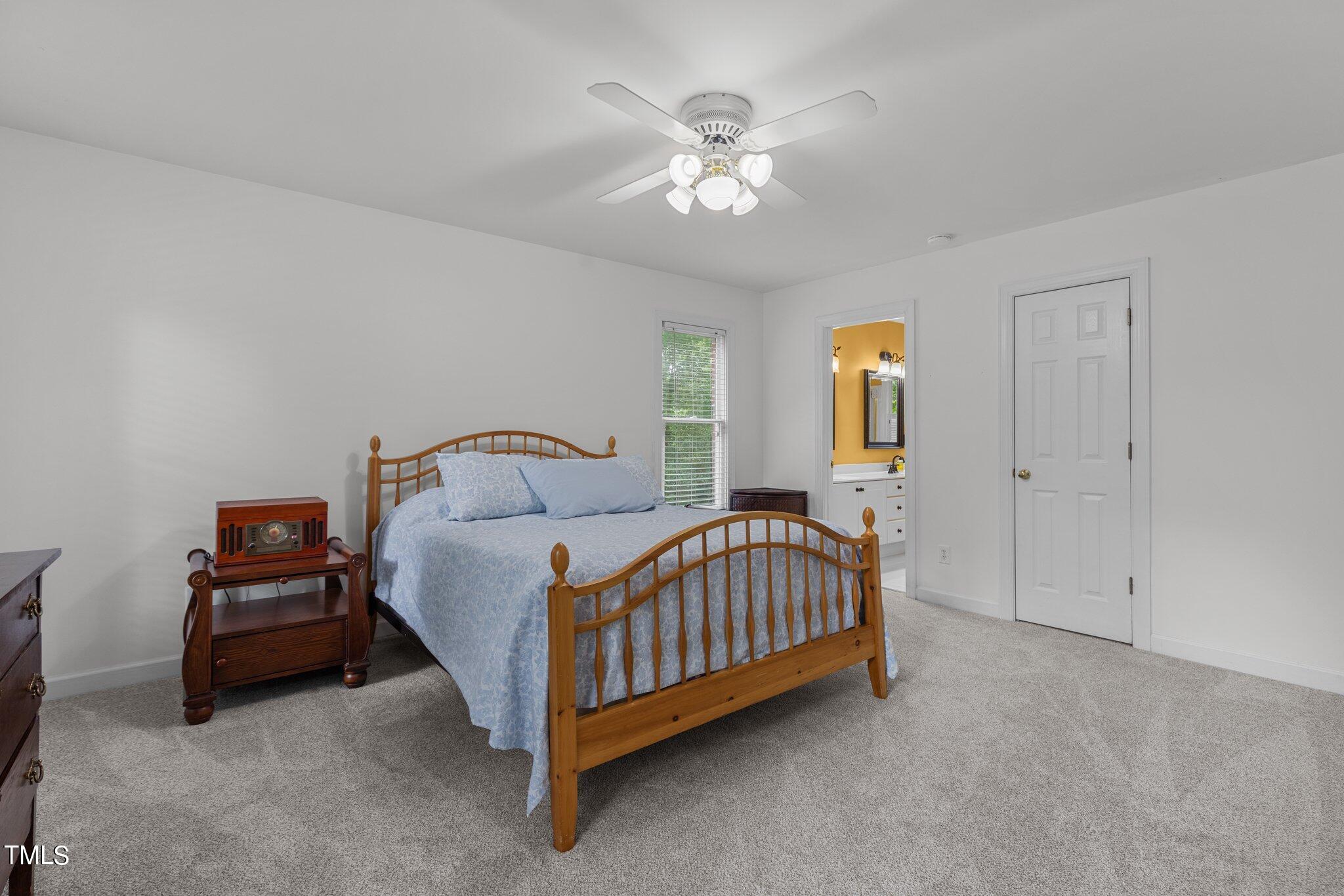 100 Shepton Drive Cary, NC 27519 - Photo 16 of 43 a bedroom with a bed and a chandelier