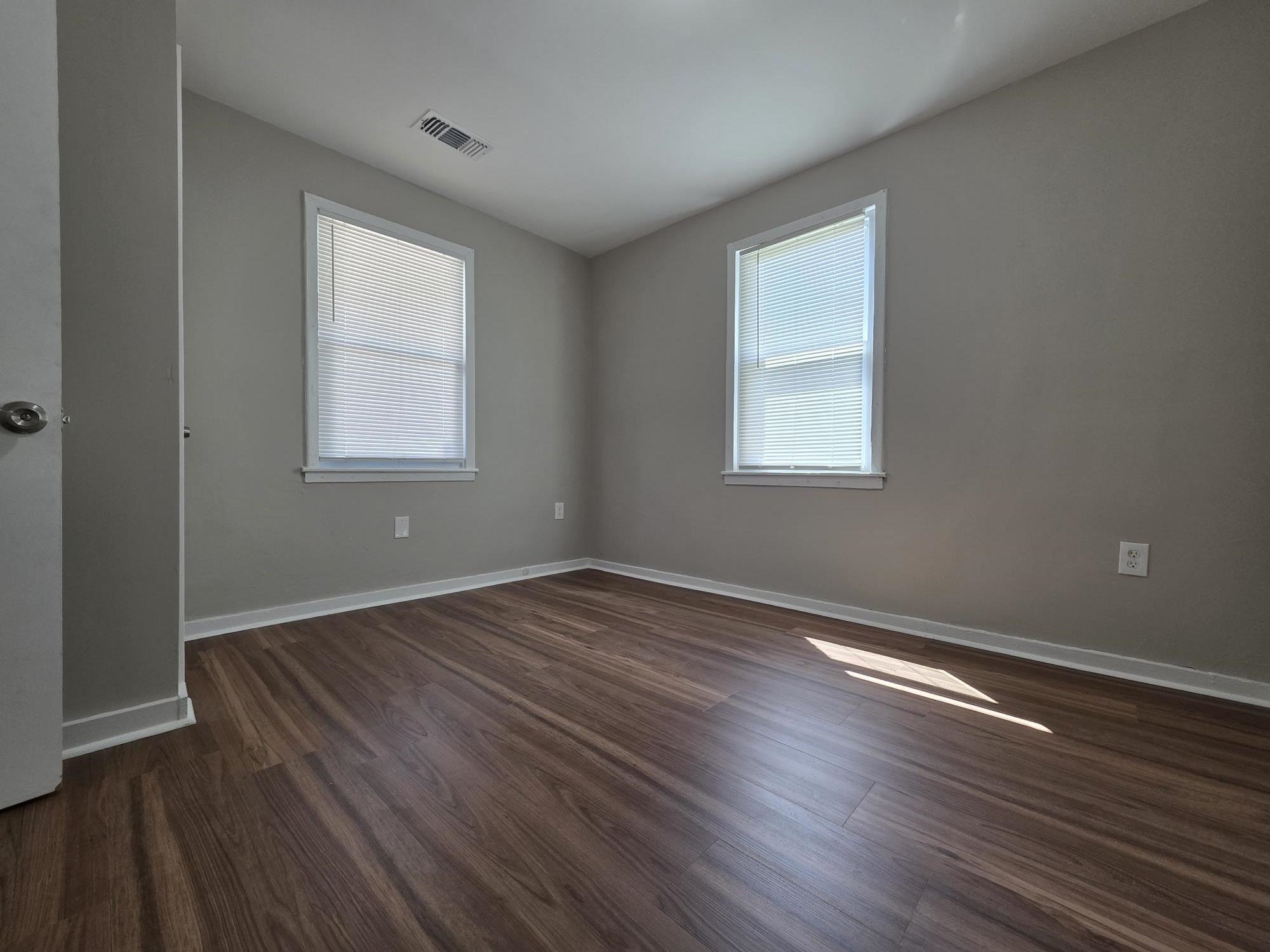 1319 Nicholas Street Memphis, TN 38107 - Photo 5 of 14 an empty room with wooden floor and windows