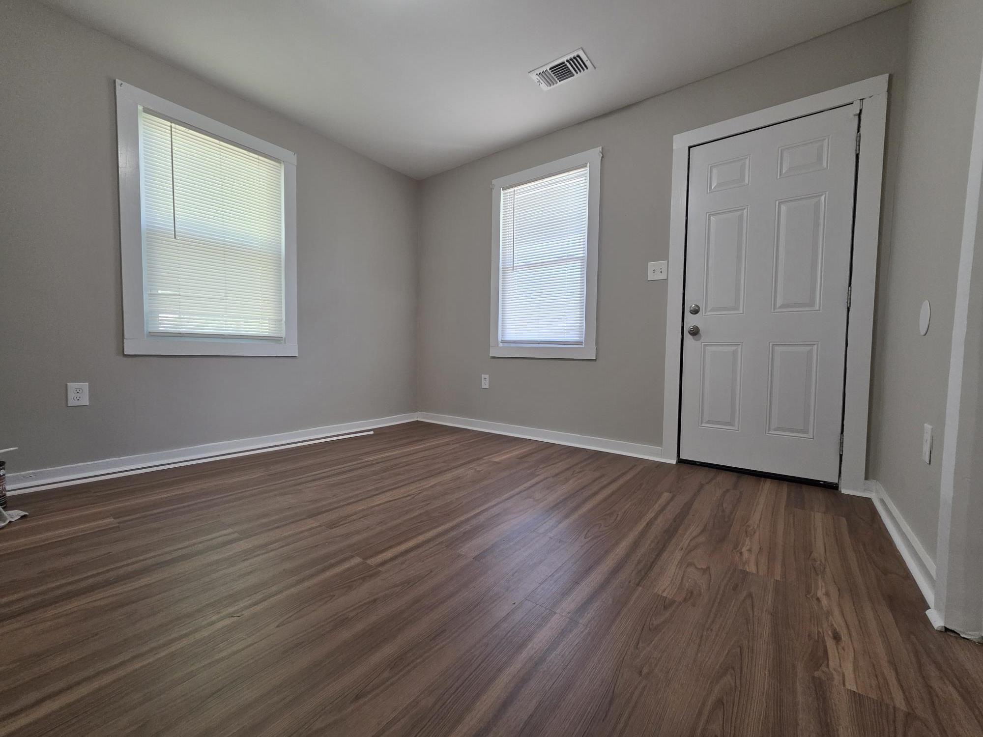 1319 Nicholas Street Memphis, TN 38107 - Photo 6 of 14 an empty room with wooden floor and windows