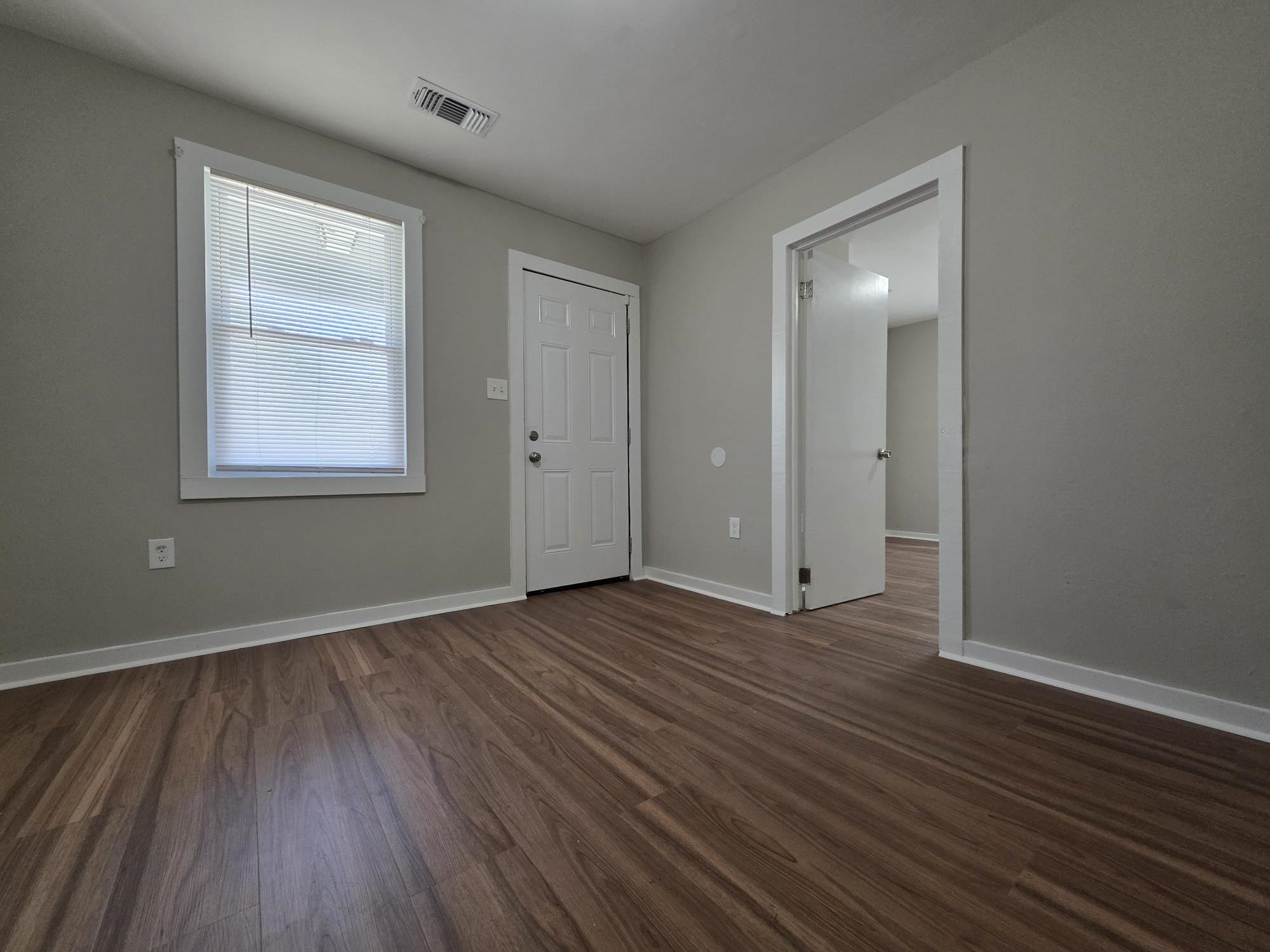 1319 Nicholas Street Memphis, TN 38107 - Photo 7 of 14 an empty room with wooden floor and windows