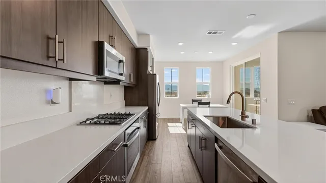 a kitchen with stainless steel appliances granite countertop a sink stove and refrigerator