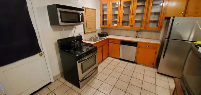a kitchen with stainless steel appliances granite countertop a refrigerator stove and microwave