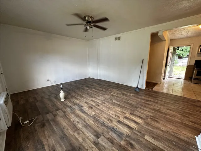 a view of a livingroom with wooden floor and a ceiling fan