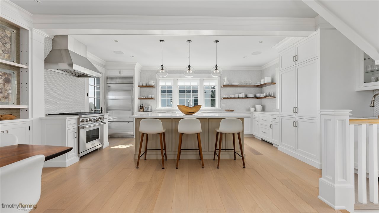 74 38th Street Avalon, NJ 08202 - Photo 18 of 39 a kitchen with stainless steel appliances a table chairs and a refrigerator