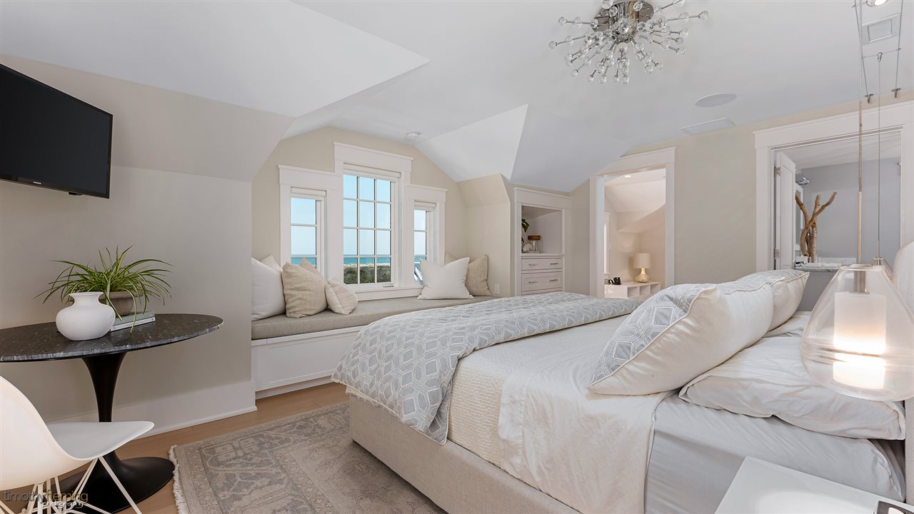 74 38th Street Avalon, NJ 08202 - Photo 30 of 39 a bedroom with a large bed and a chandelier