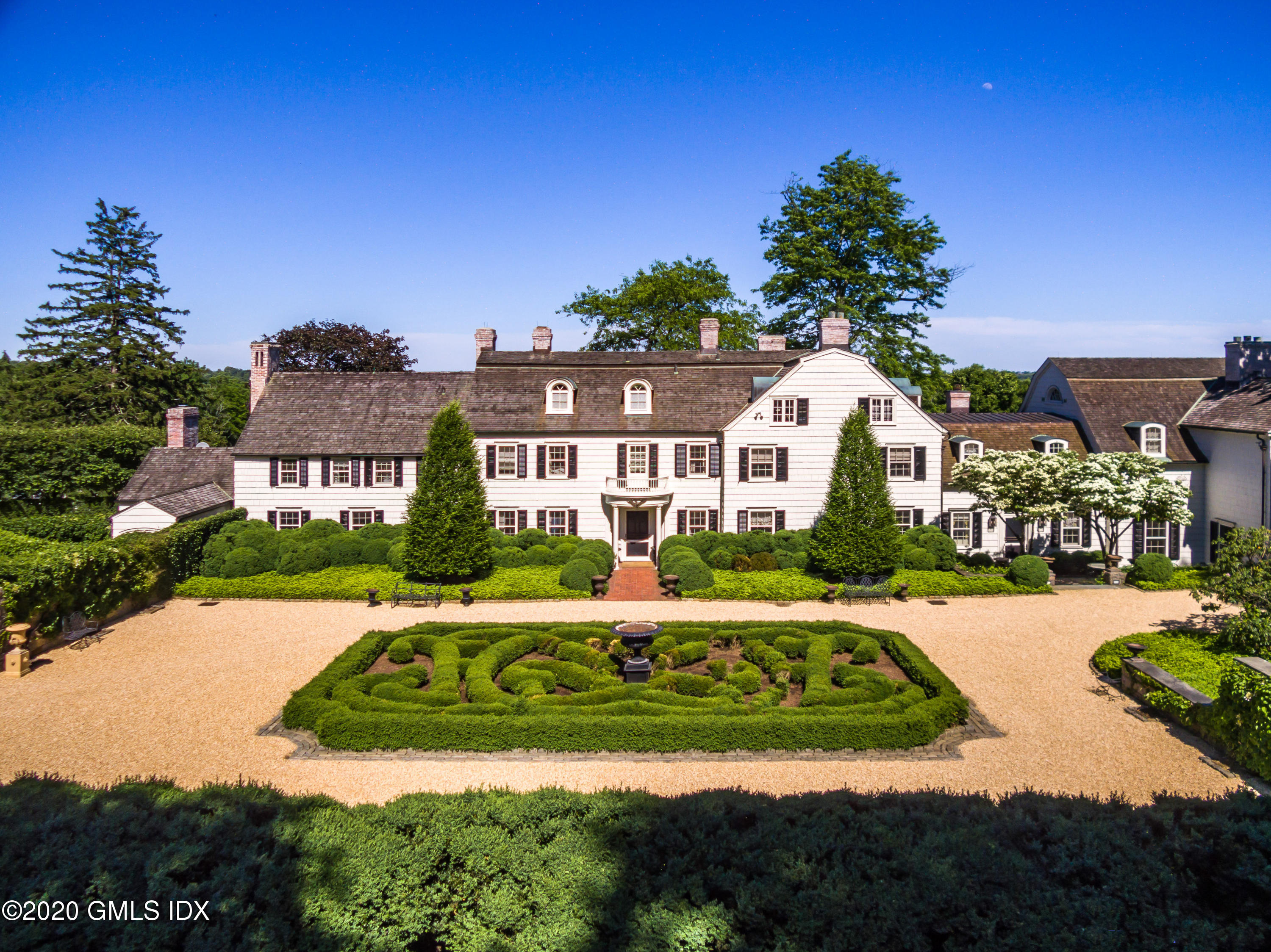 591 Riversville Road Greenwich, CT 06831 - Photo 3 of 79 a front view of a house with a garden and trees