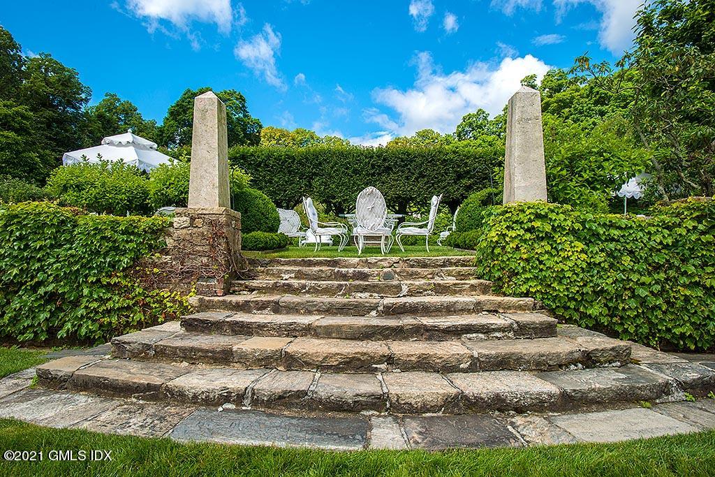 591 Riversville Road Greenwich, CT 06831 - Photo 38 of 79 a view of a garden with a fountain