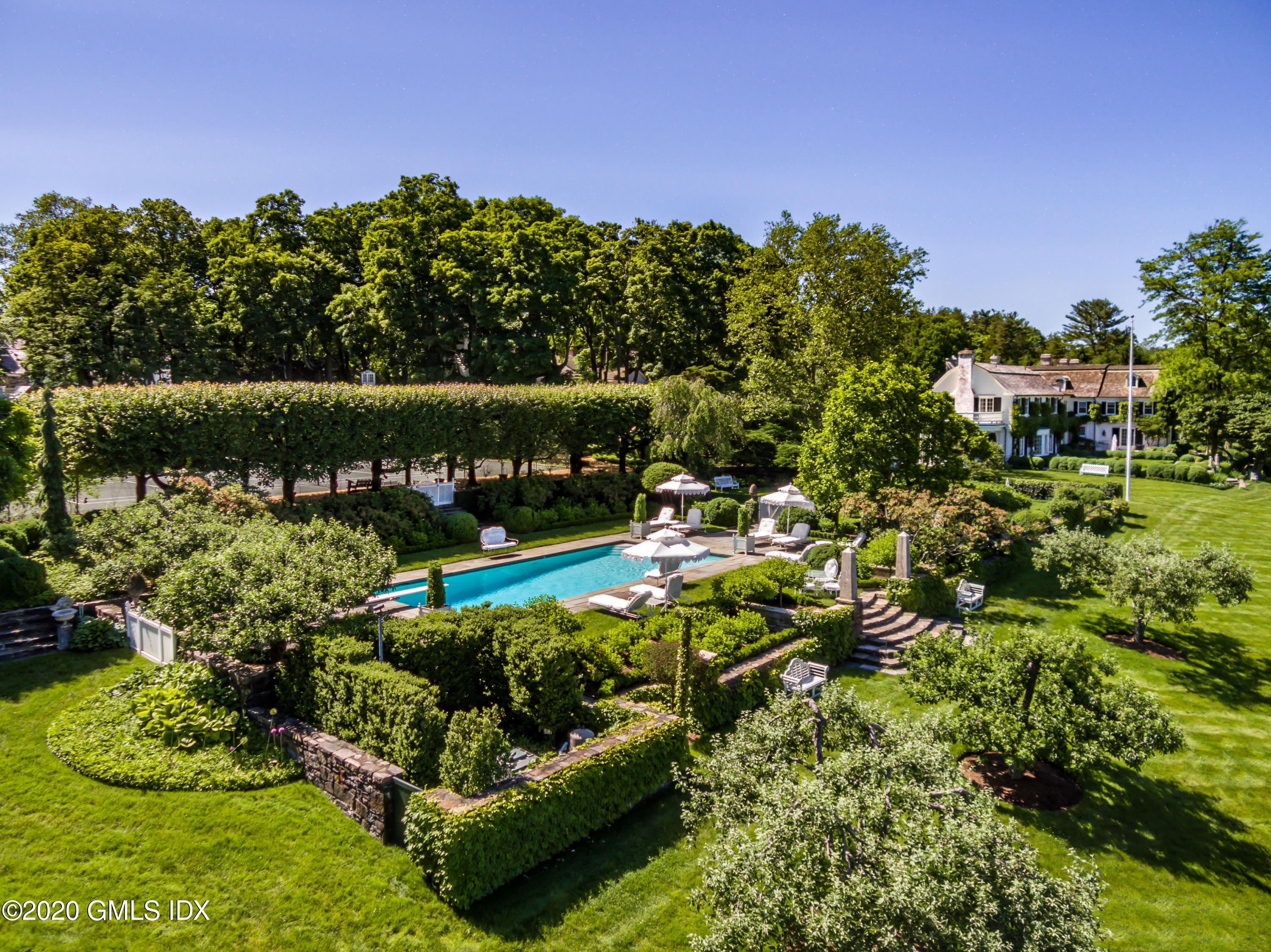 591 Riversville Road Greenwich, CT 06831 - Photo 39 of 79 a view of a garden with plants and a fountain