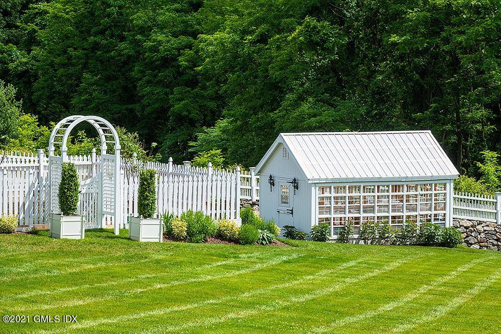 591 Riversville Road Greenwich, CT 06831 - Photo 78 of 79 a front view of a house with a garden
