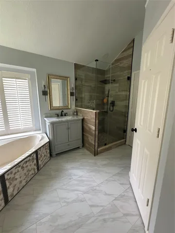 a bathroom with a tub sink and mirror