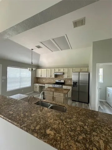 a large kitchen with kitchen island a sink stainless steel appliances and cabinets