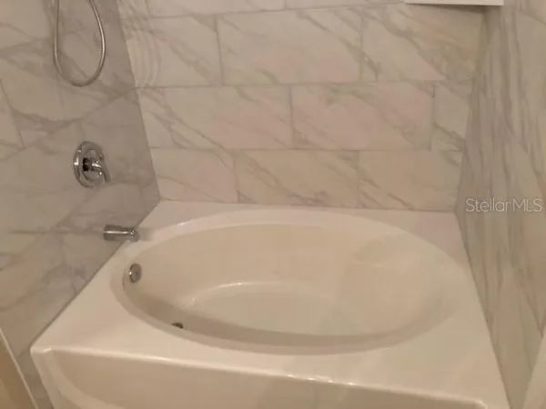 a white bath tub sitting in a bathroom and shower