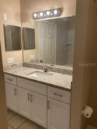 a bathroom with a granite countertop sink a mirror and a
