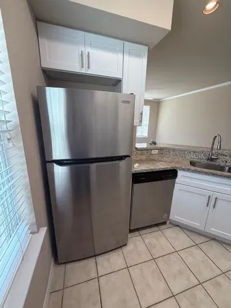 a kitchen with granite countertop a refrigerator and a sink