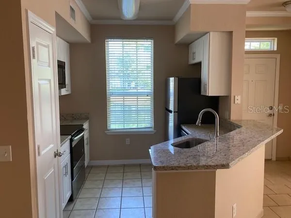 a kitchen with granite countertop a sink stove and refrigerator