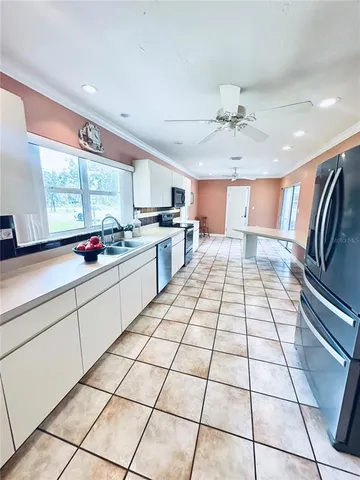 a kitchen with stainless steel appliances kitchen island granite countertop a sink and cabinets