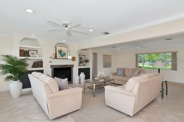 a living room with furniture a fireplace and a potted plant