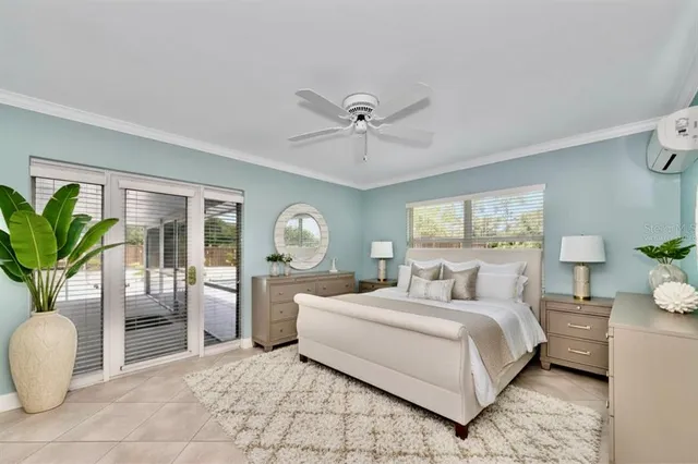 a bedroom with a large bed and a potted plant