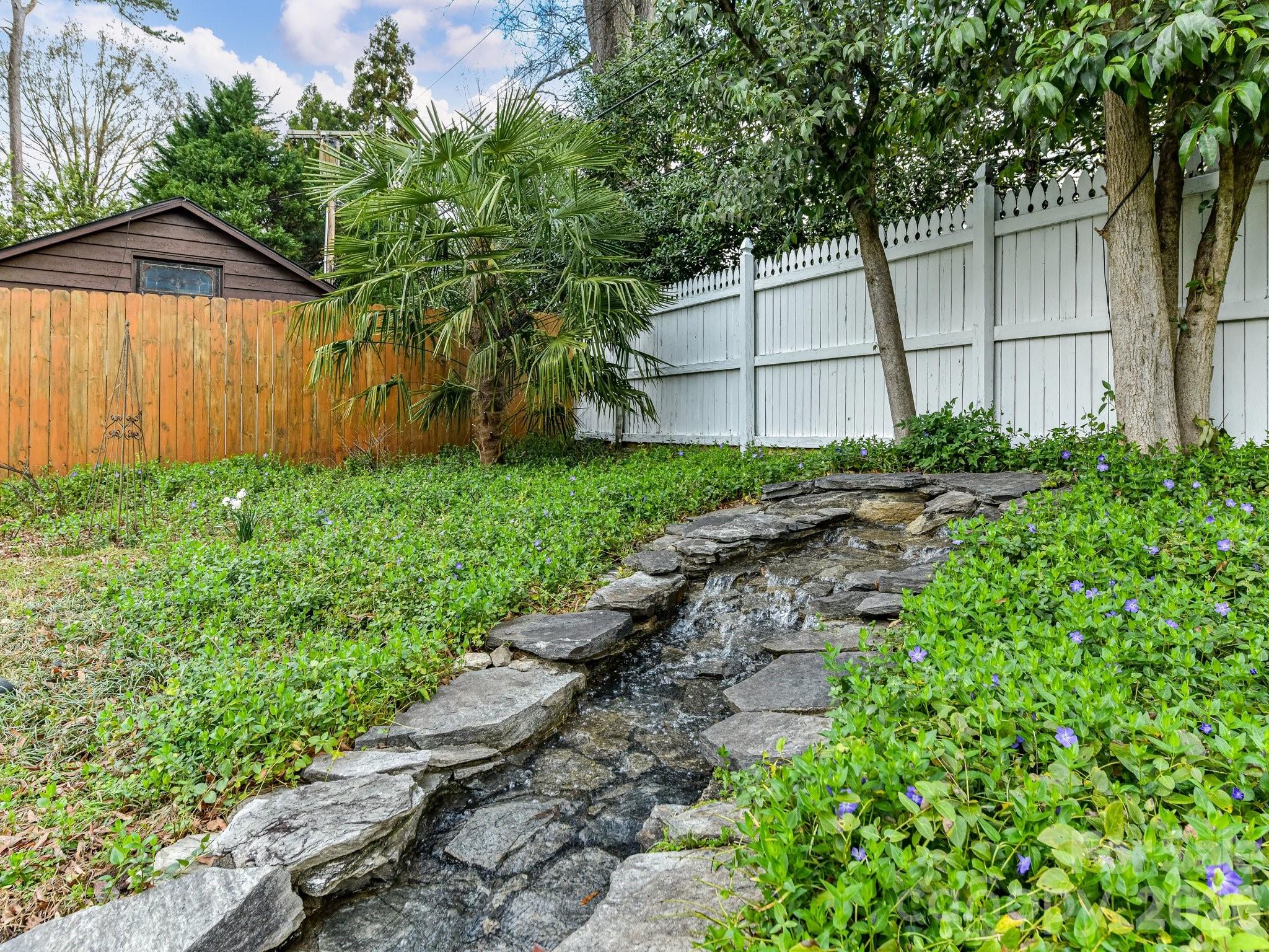 1535 Providence Road Charlotte, NC 28207 - Photo 11 of 42 a backyard of a house with lots of green space and wooden fence