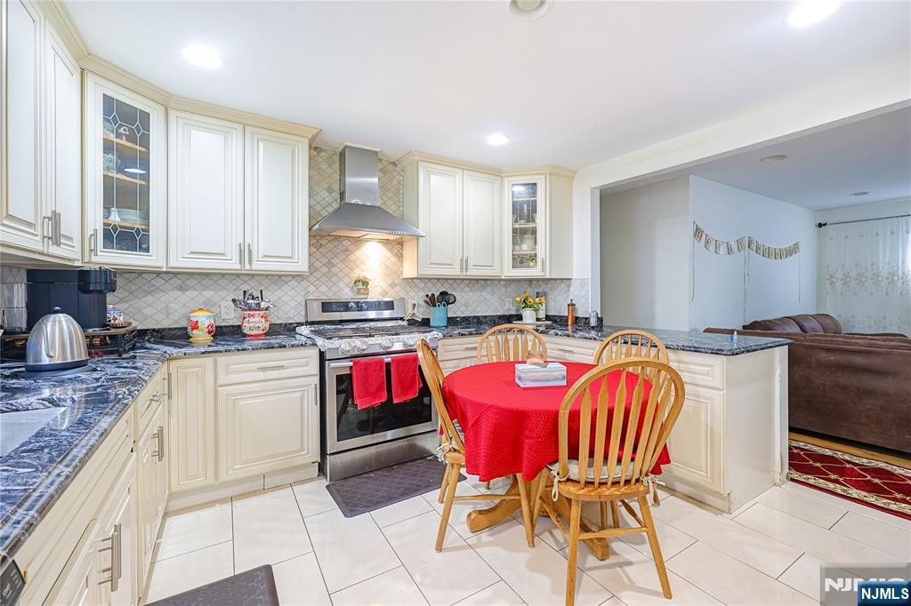698 Fairview Avenue Fairview, NJ 07022 - Photo 4 of 40 a large kitchen with granite countertop a stove a sink a table and chairs