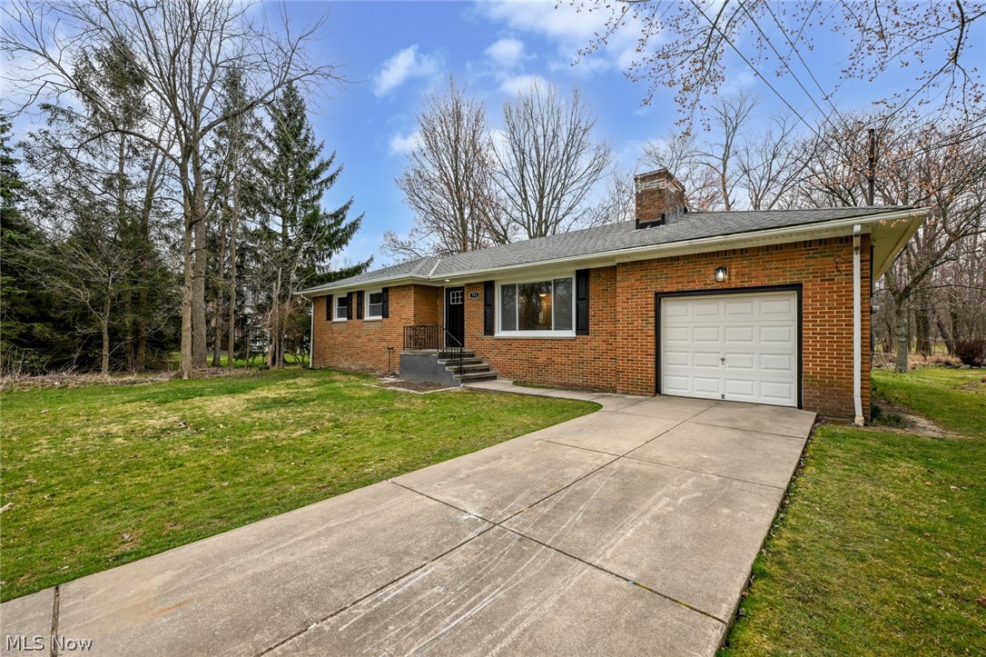 Ranch-style home with a front yard and a garage
