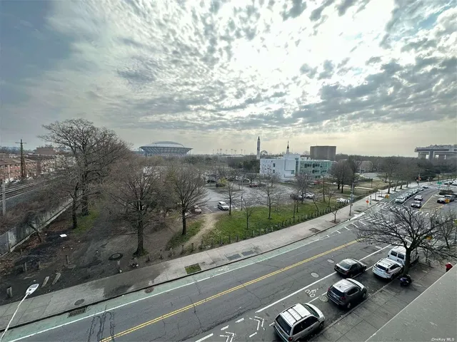 a view of a city street with a car parked on the road