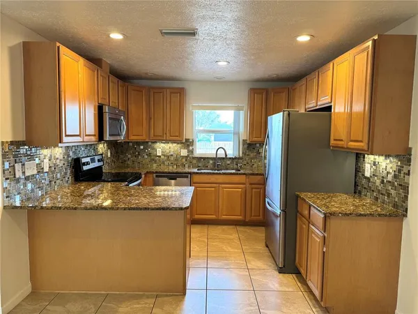 a kitchen with stainless steel appliances granite countertop a sink counter space cabinets and a large window