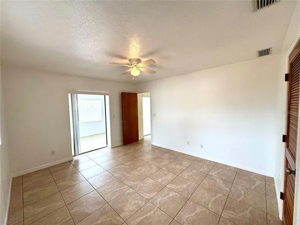 en empty room with windows and fan