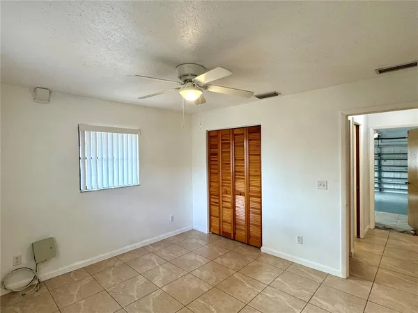 an empty room with windows and closet