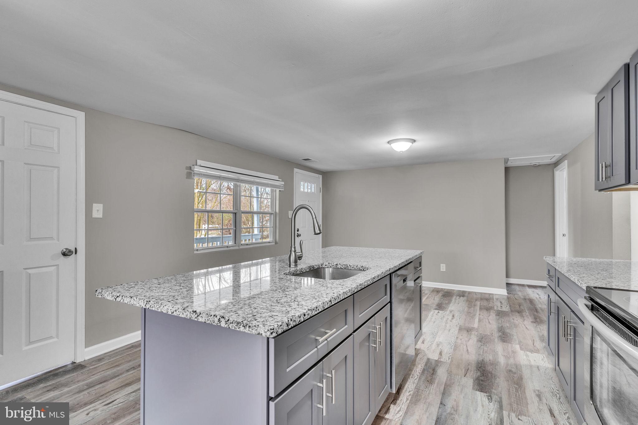 24338 Longview Road Chaptico, MD 20621 - Photo 17 of 19 a kitchen with granite countertop a sink and cabinets