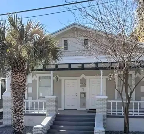 a front view of a house with a tree