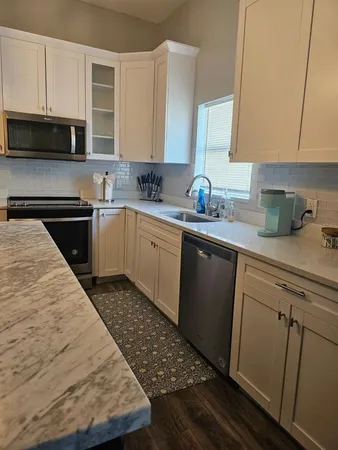 a kitchen with sink cabinets and stainless steel appliances