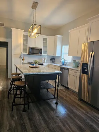 a kitchen with a dining table chairs appliances and cabinets