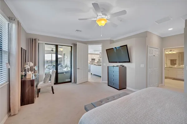 a spacious bedroom with a bed and a lamp on dresser