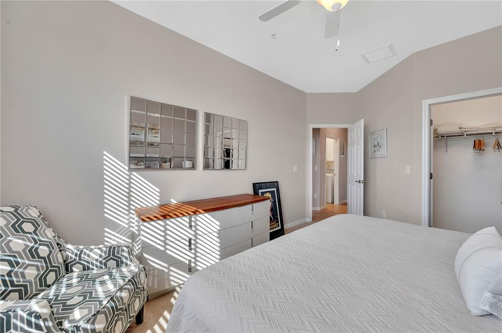 5815 Wake Forest Run, Unit 103 Lakewood Ranch, FL 34211 - Photo 21 of 63 a bedroom with a bed and a chandelier