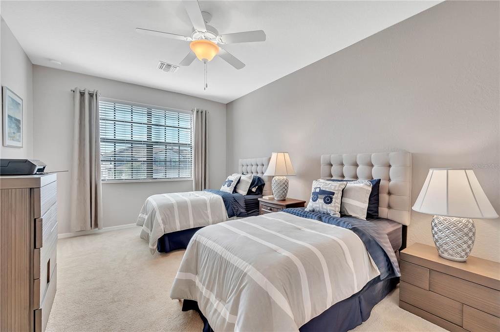 5815 Wake Forest Run, Unit 103 Lakewood Ranch, FL 34211 - Photo 22 of 63 a bedroom with two beds and a chandelier