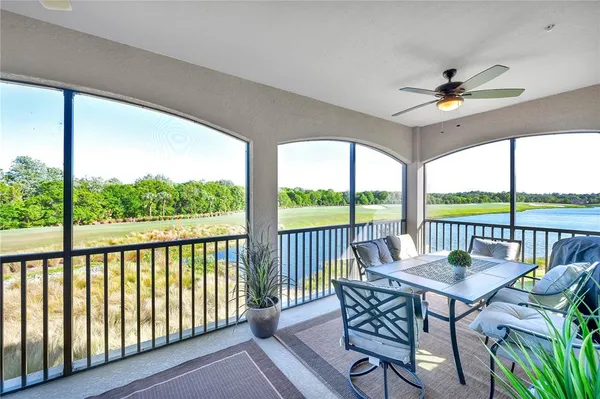 a view of a lake with lawn chairs and a table
