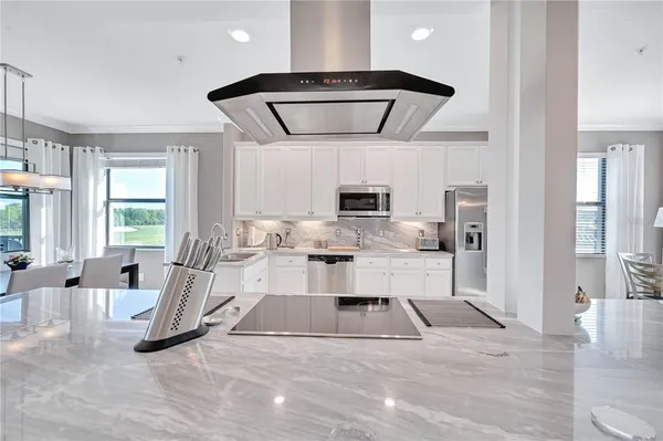 a kitchen with a refrigerator and a stove top oven